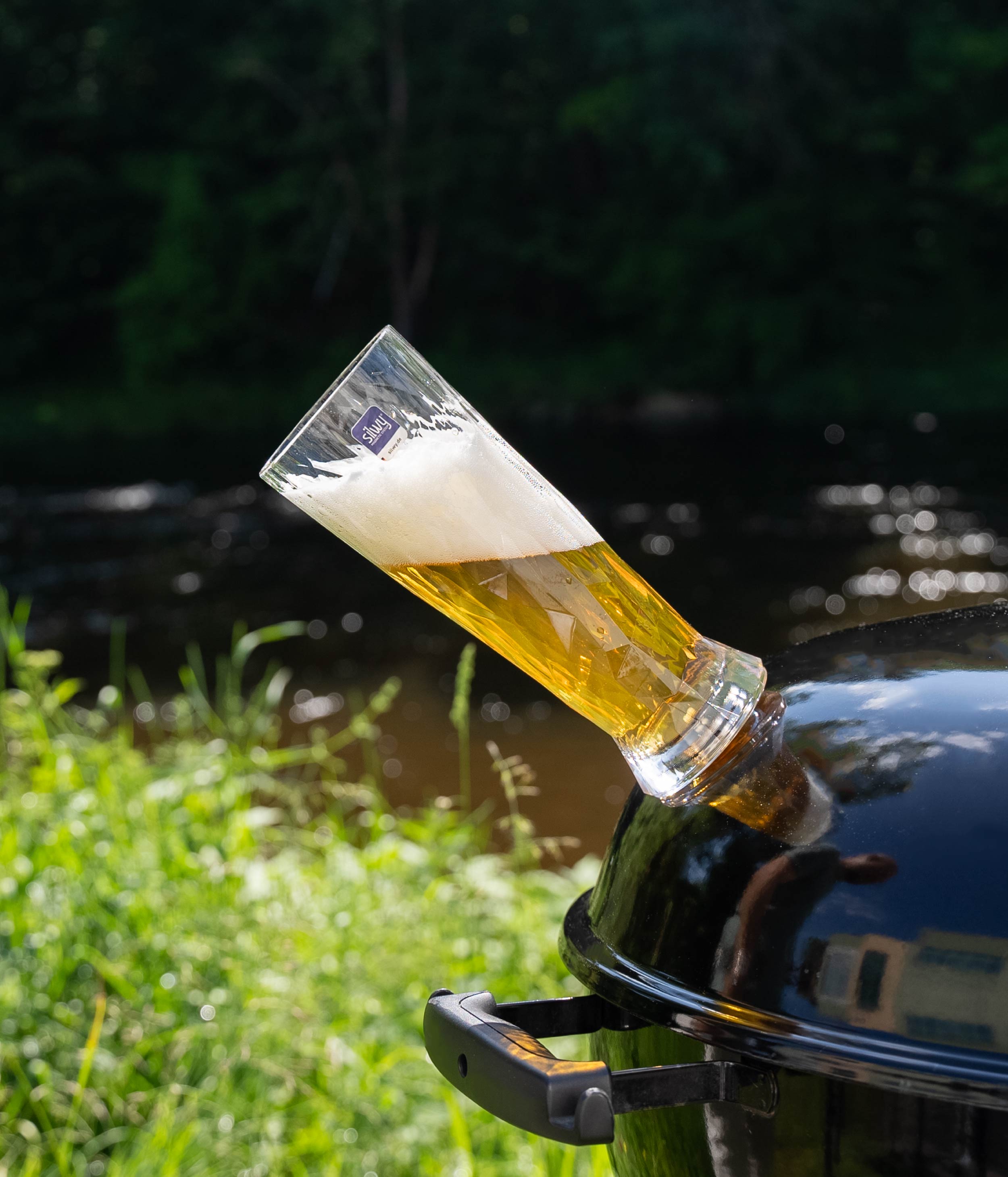 Magnetisches Kunststoffbierglas auf einem Kugelgrill