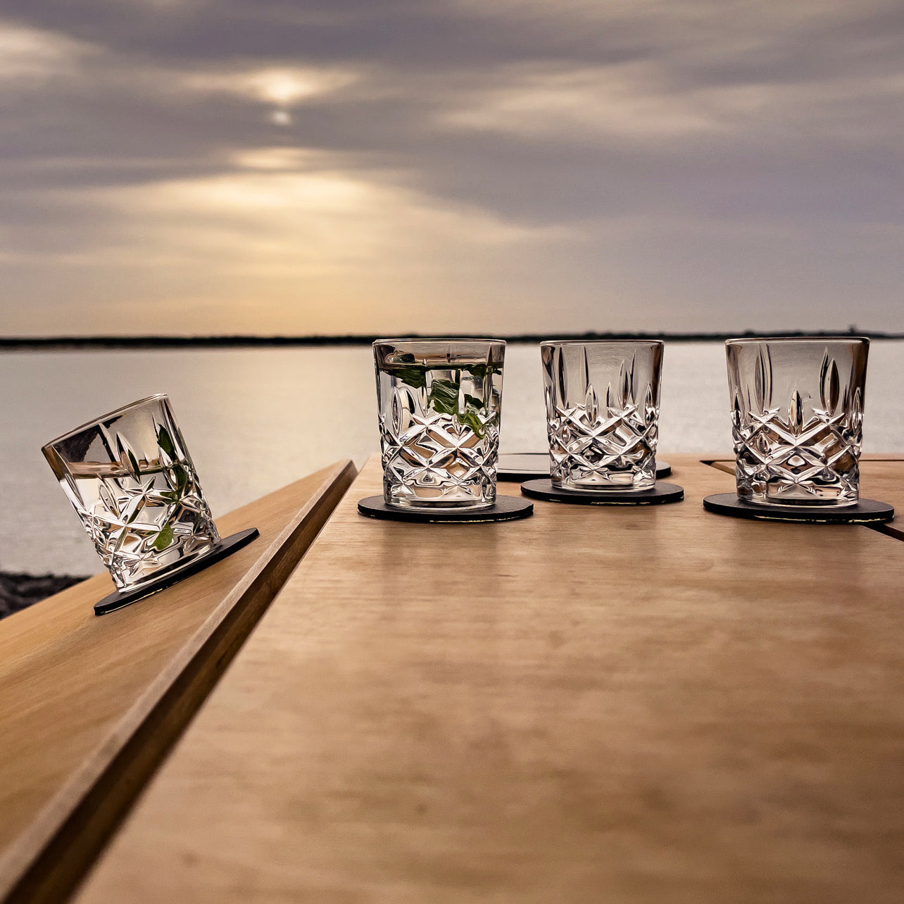 Vier Kristallgläser Whisky auf Tisch mit Metall-Nano-Gel-Pads