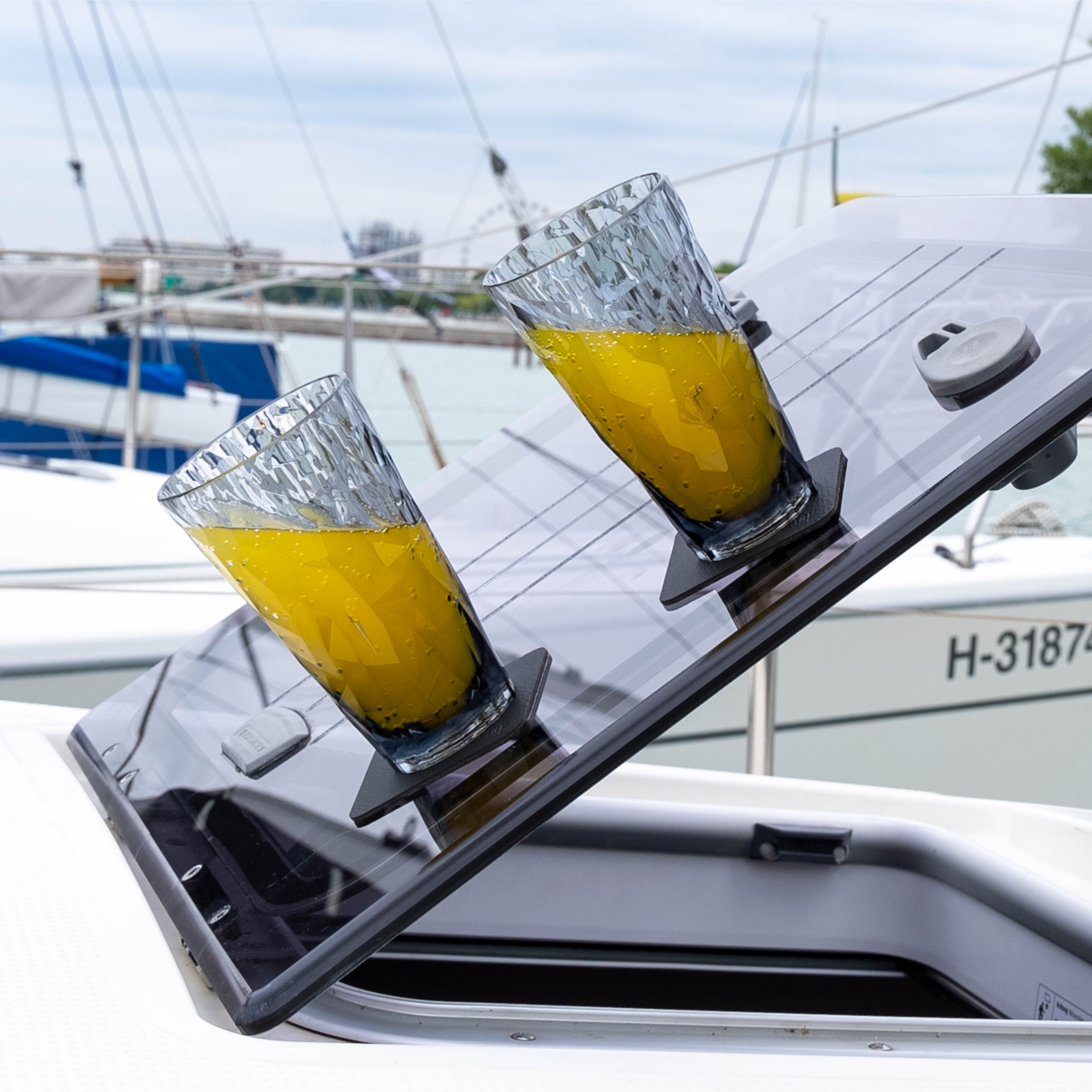 Zwei Kunststoff-Longdrinkgläser mit Magnet in Schräglage auf einem Boot