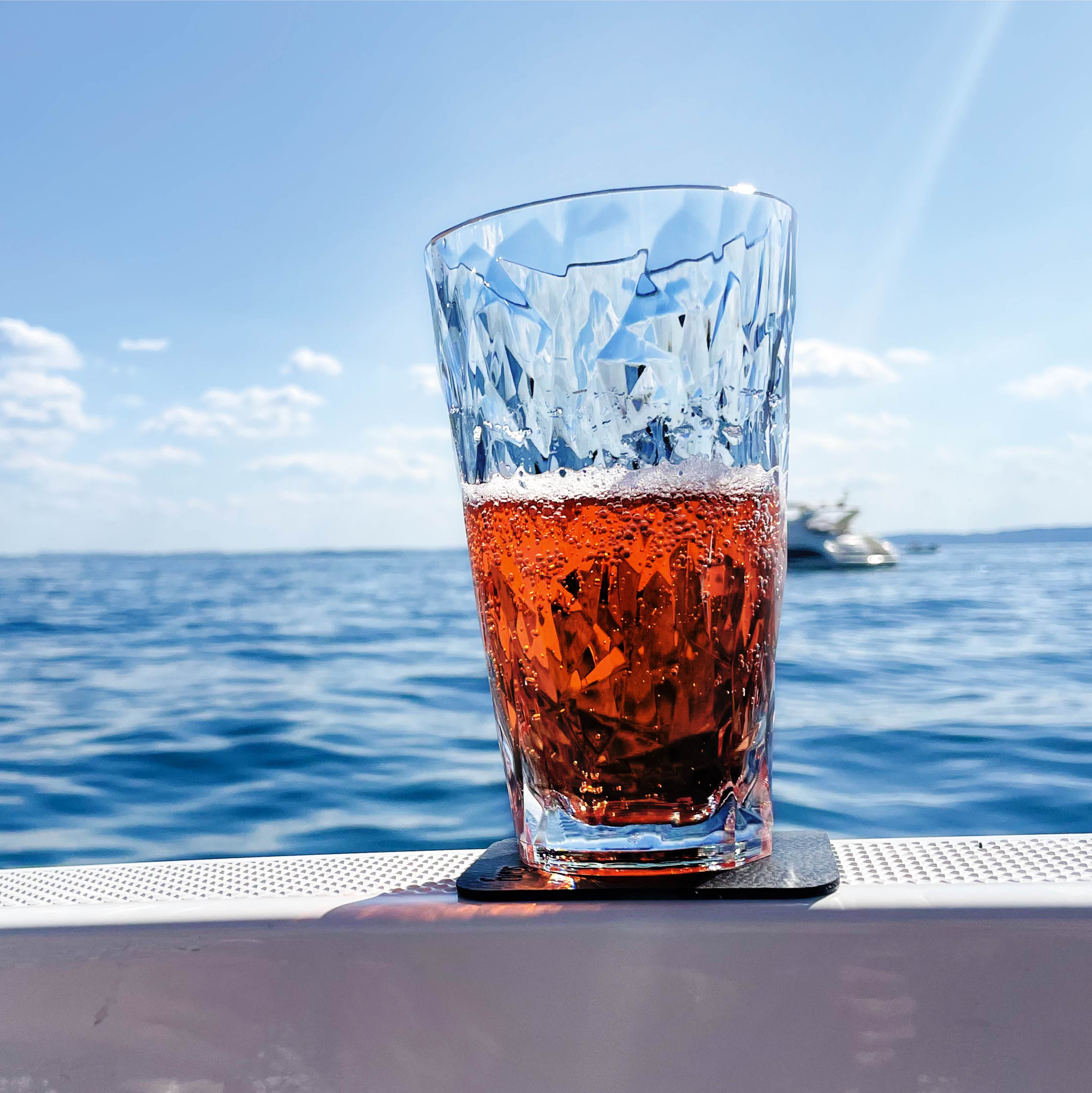 Magnet-Kunststoffglas Longdrink abgestellt auf einem Pad auf einem Boot während der Fahrt