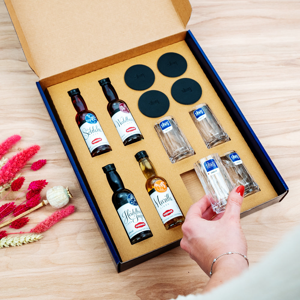 Geschenkbox Penninger - Blaue Verpackung mit 4 Magnet-Kunststoffgläsern Shot, 4 kleinen Flaschen Penninger und runden Metall-Nano-Gel-Pads in schwarz