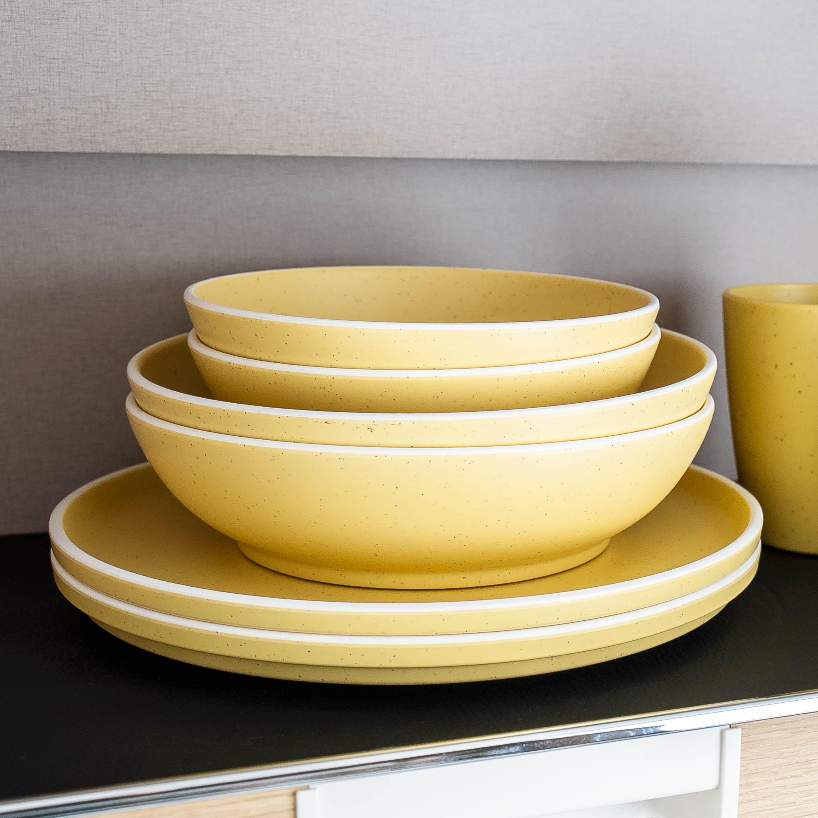 Kunststoff-Geschirrset Yellow auf Matte im Camper