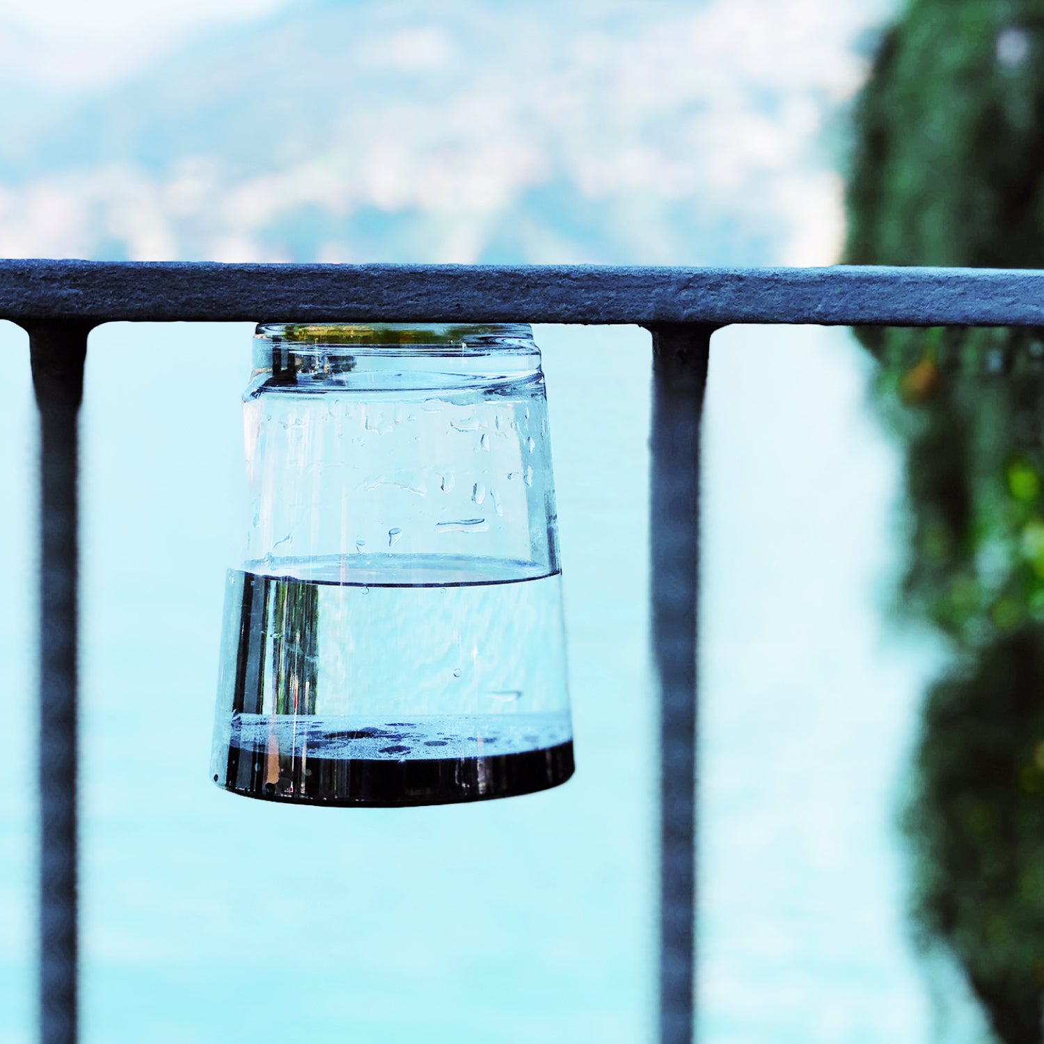 Magnet-Trinkbecher Classic, gefüllt mit Wasser - kopfüber an einer Metall-Brücke befestigt