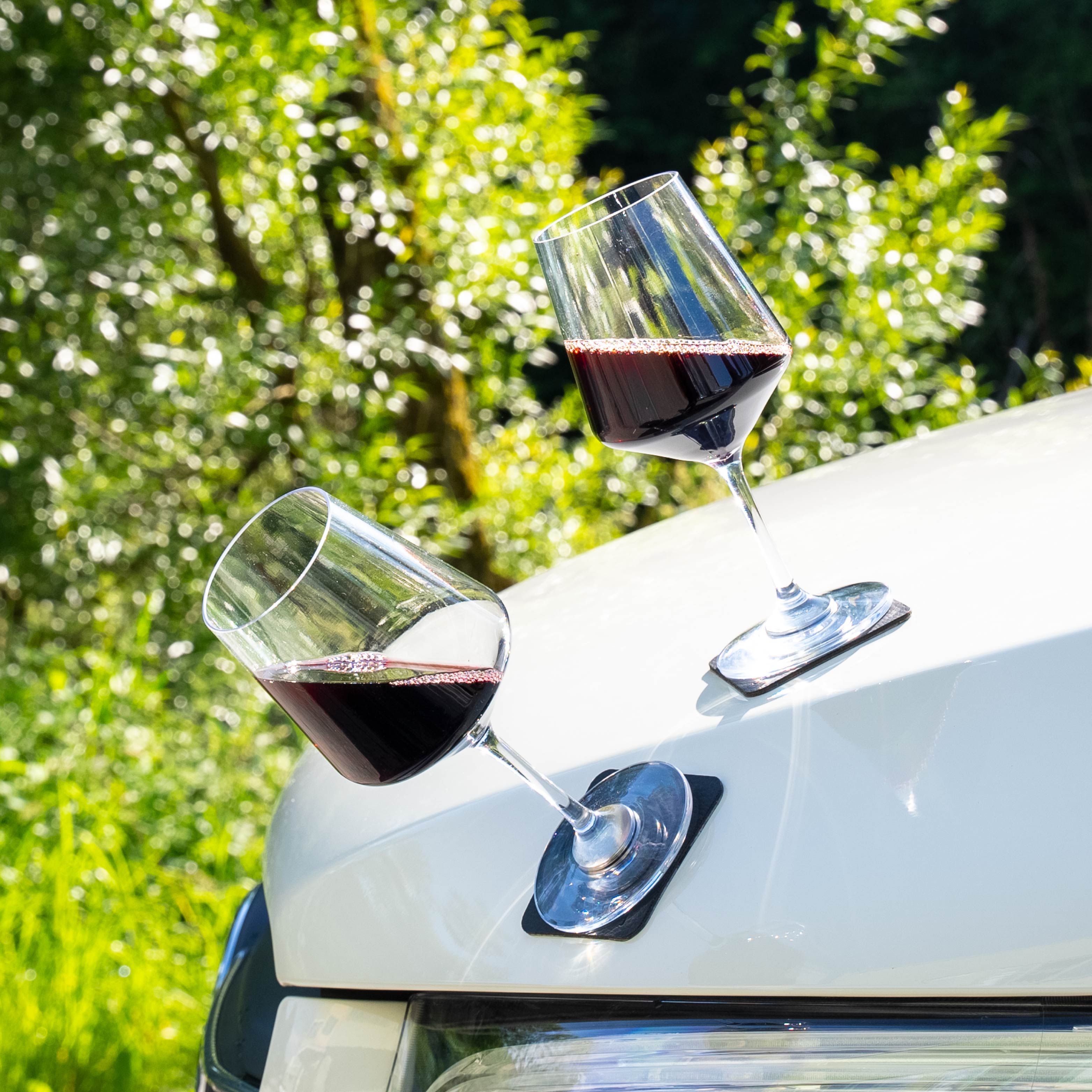 Magnet-Kunststoffgläser Wein auf metallischer Motorhaube abgestellt