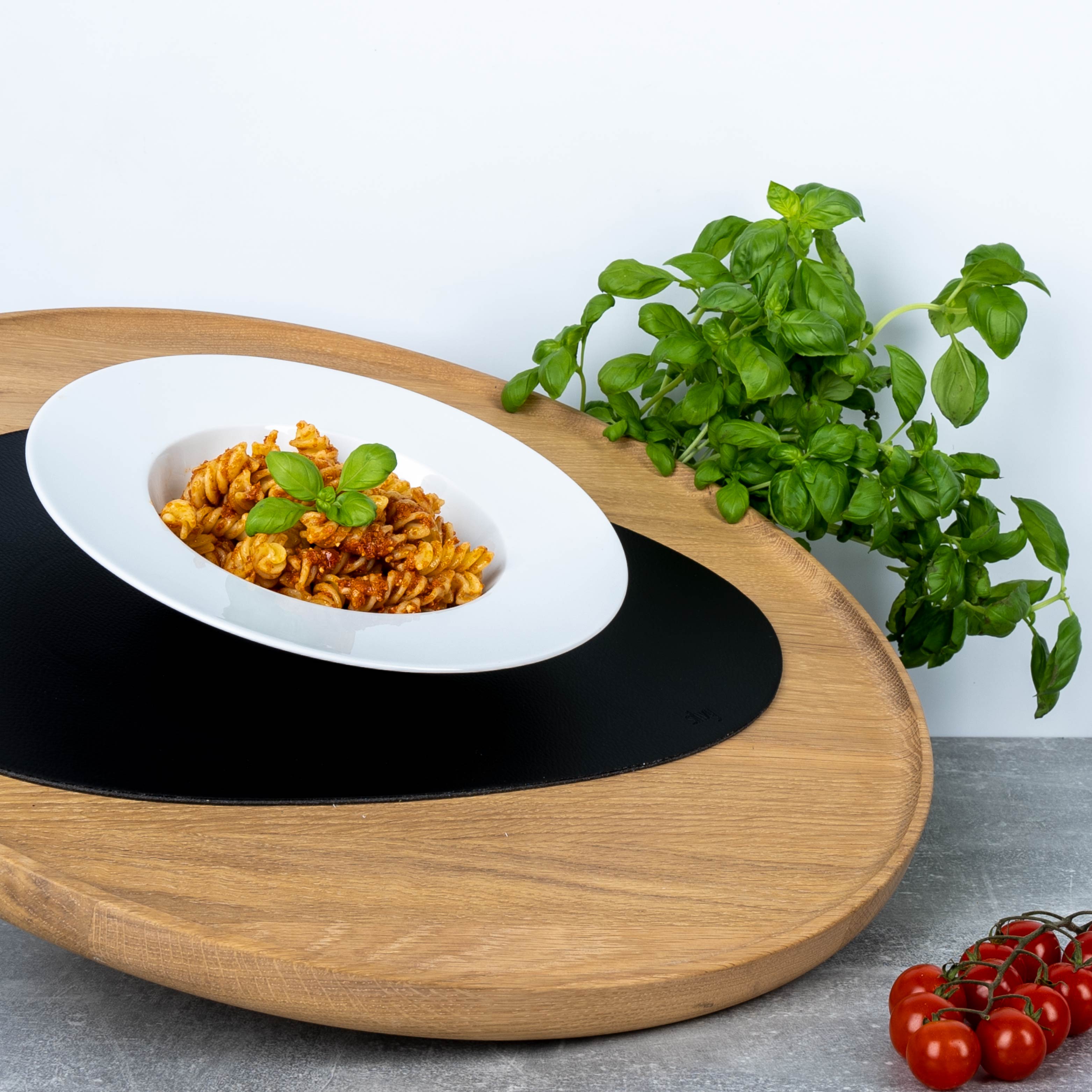 Magnet-Porzellan-Gourmetteller mit Nudeln und Basilikum auf Platzset auf Holztablett