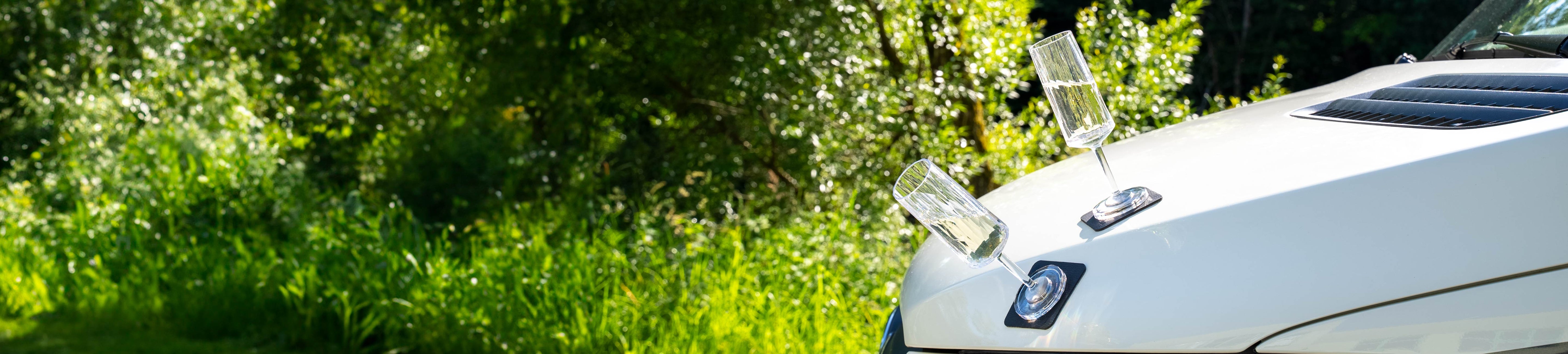 Magnet-Kunststoffgläser Sekt auf einer metallischen Motorhaube abgestellt